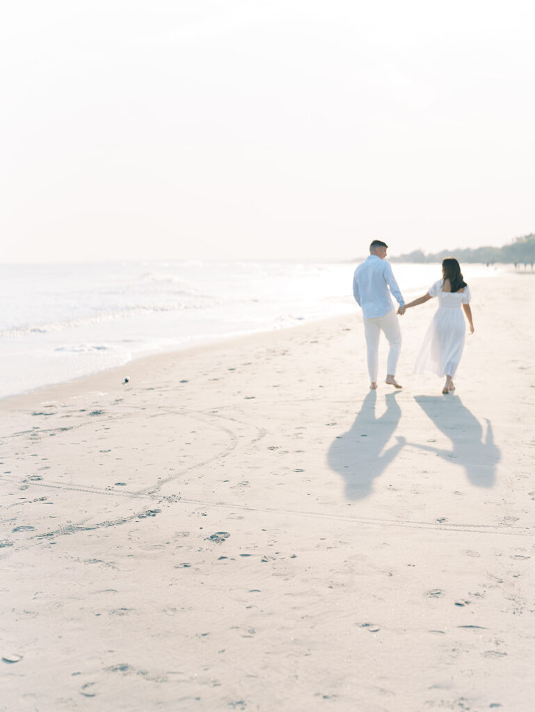 couple walking on the beach holding hands during Isle of Palm engagement session