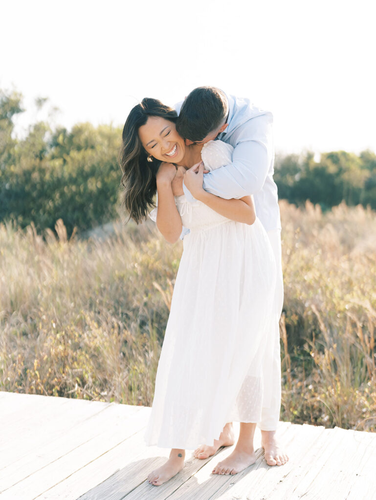 couple embracing on boardwalk at Isle of Palm engagement session location