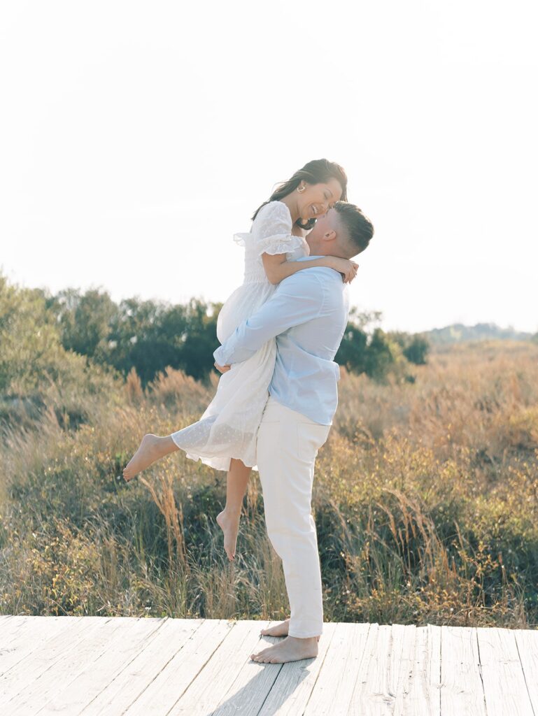 Isle of Palm engagement session, guy holding fiance on board walk at Isle of Palm